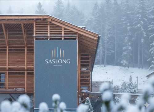 a building with a sign on it in the snow at Alpstay - Smart Hotel Saslong in Santa Cristina in Val Gardena