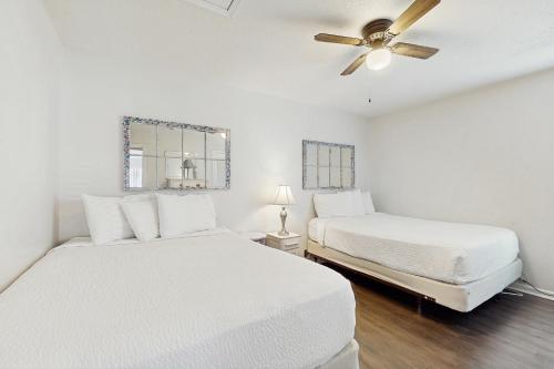 una camera bianca con 2 letti e un ventilatore a soffitto di Horizon South 23D a Panama City Beach