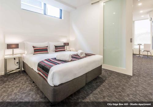 a bedroom with a large bed in a room at Comfort Apartments Box Hill in Box Hill