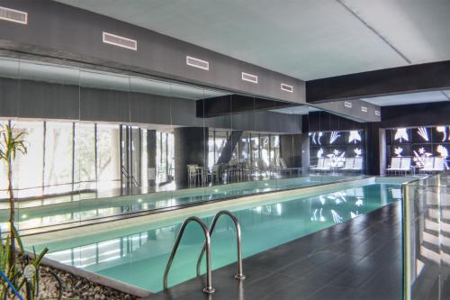 a swimming pool with blue water in a building at Reforma 284 King Size SUITE Swimming Pool, Parking & Kitchen in Mexico City