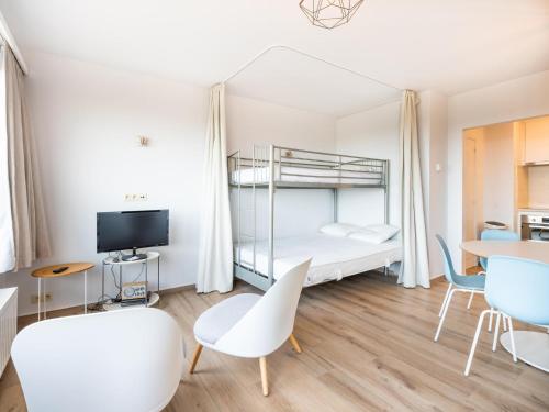 een studio-appartement met een bed, tafels en stoelen bij Manderley tweede in Oostduinkerke-Bad