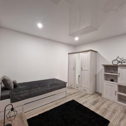 een witte slaapkamer met een bed en een kast bij Ferienwohnung Lüchtringen in Höxter