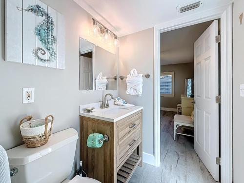 a bathroom with a sink and a toilet and a mirror at Waves 9 in St Pete Beach