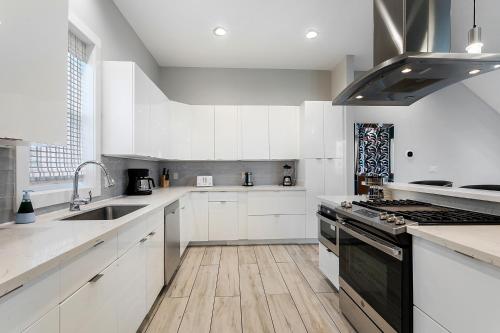 a kitchen with white cabinets and a stove top oven at Luxury 3-Story Home w Pool & Parking garage in New Orleans