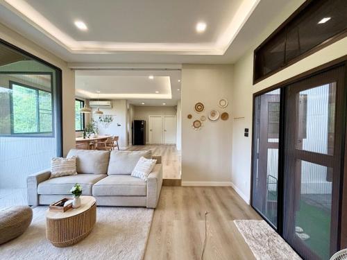 a living room with a couch and a table at Villa 107 with private patio and balcony in Ban Yang Pa Kha