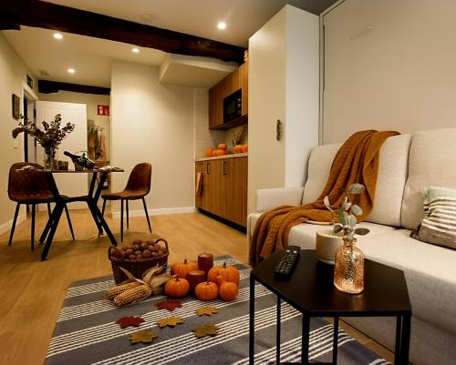 Sala de estar con sofá y mesa con calabazas en APARTAMENTOS BOUTIQUE ALTZOAN Aparcamiento gratis y supermercado a 2 metros, en Zarautz