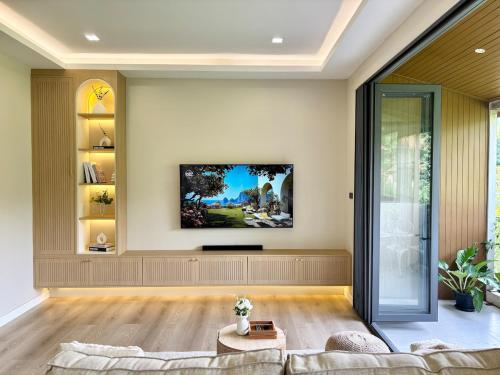 a living room with a couch and a tv at Villa 107 with private patio and balcony in Ban Yang Pa Kha