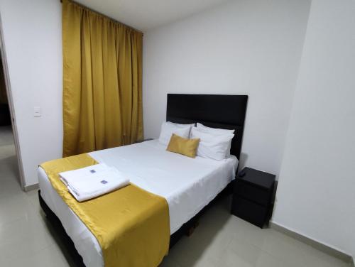1 dormitorio con 1 cama grande y cortina amarilla en Habitacion con baño privado , comodida, en Cali