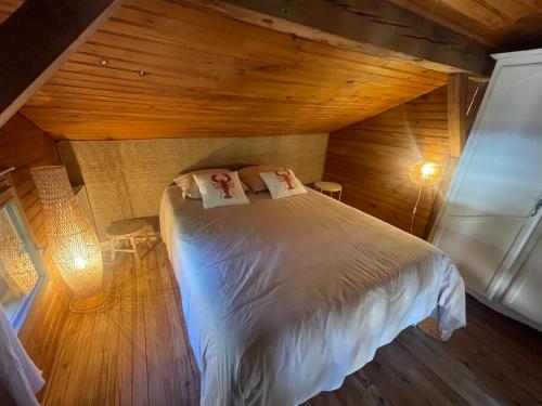 a bedroom with a bed in a wooden room at Gites Airial cazalas in Argelouse