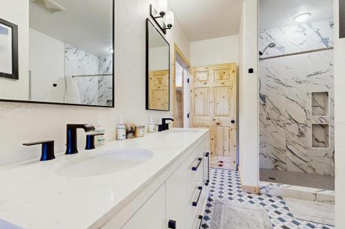 a white bathroom with a sink and a shower at Riverfront Lodge in Pagosa Springs