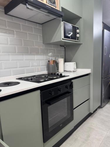 a kitchen with a black and white stove top oven at Closer to CBD by UrbanCove in Nelspruit