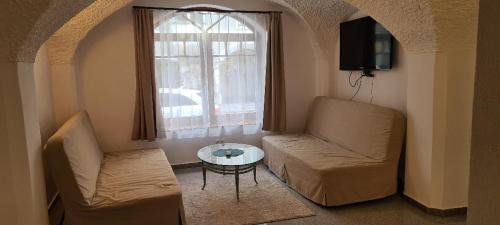 Una sala de estar con un sofá y una mesa y una ventana. en ALTSTADT-Apartmenthaus BOGENSPERGER, en Braunau am Inn
