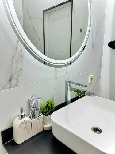 a bathroom with a white sink and a mirror at K7 Family in Atyraū