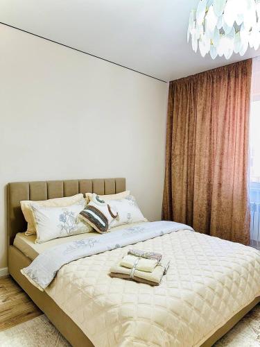 a bedroom with a large bed with towels on it at K7 Family in Atyraū