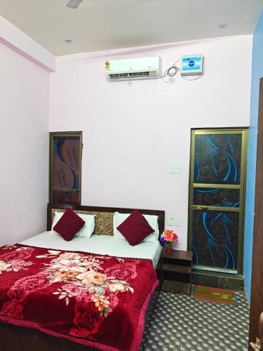 a bedroom with a bed with a red comforter at Krishna guest House luxury stay in Ayodhya - 600 meter away from ram mandir in Ayodhya