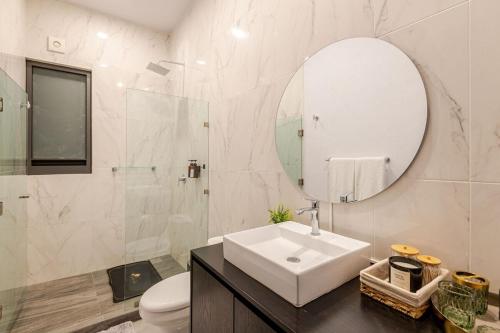 a white bathroom with a sink and a mirror at Luxury apartment overlooking the Arch in Cabo San Lucas