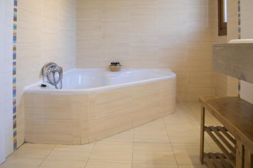 a bath tub in a bathroom with a tile floor at Villa Playa de Barro in Barro de Llanes