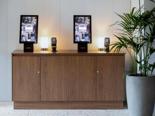 a reception desk with two screens on top of it at ibis Styles Sydney Central in Sydney