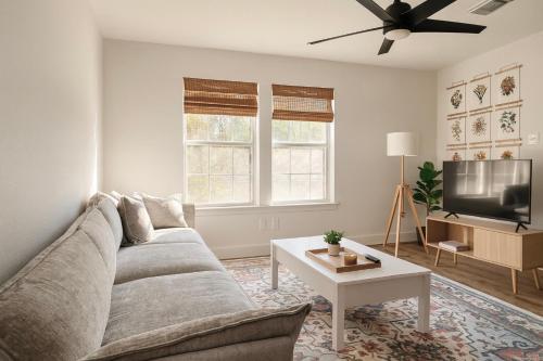 a living room with a couch and a tv at Stylish Stays in Historic Fourth Ward in Houston
