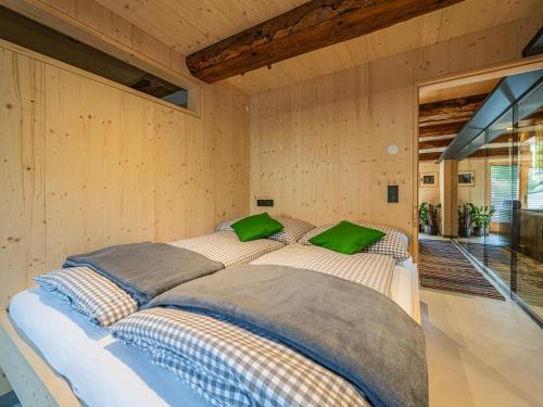 a large bed in a room with wooden walls at Raneburg 4 Stallhaus in Matrei in Osttirol