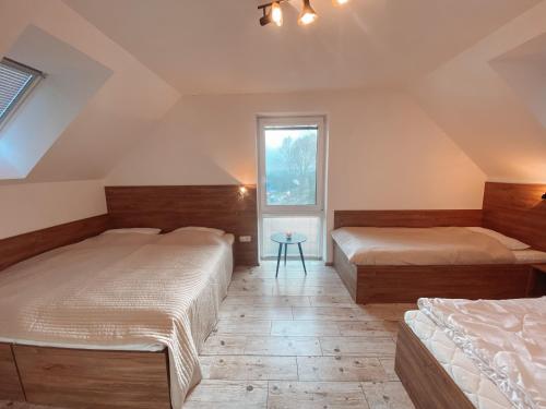 a bedroom with two beds and a window at Chalet Dolní Morava in Dolní Morava