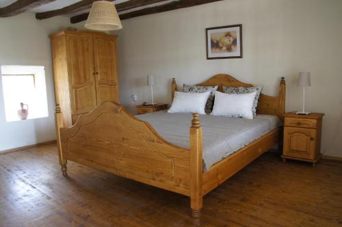 a bedroom with a wooden bed and a wooden cabinet at Botev Houses in Mirovets