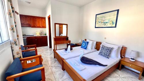 a bedroom with two beds and a kitchen at Avlakia Sunrise Haven Studios in Avlákia