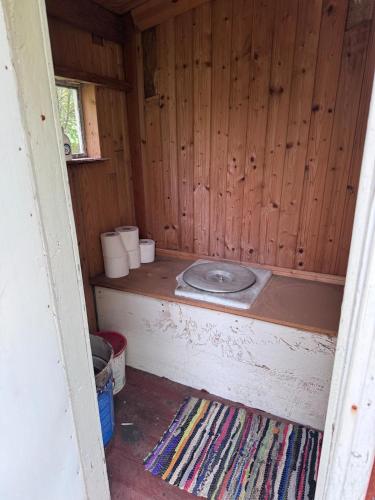 a room with a toilet in a wooden cabin at Mummon mökki in Mäntylahti