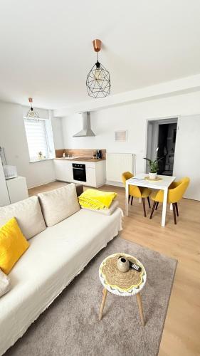 Una sala de estar con un sofá blanco y una mesa. en Charmant petit F1 avec jardin, en Béning-lès-Saint-Avold