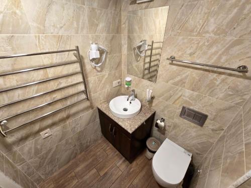 エレバンにあるYour Yerevan Homeの白いトイレと洗面台のあるバスルーム
