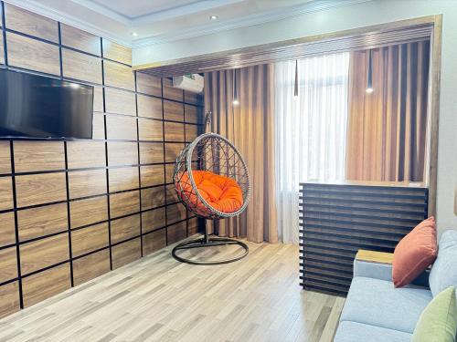 a chair with an orange pillow in a room at Happy House in Samarkand
