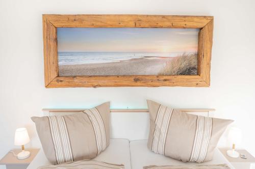 a picture of the beach in a frame on a wall at Inselblume 66 - Kuschlige Ferienwohnung für 2 in Landkirchen in Landkirchen