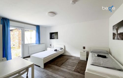 una habitación blanca con una cama y una mesa en BEGE APARTMENTS PrimeWork, en Hagen