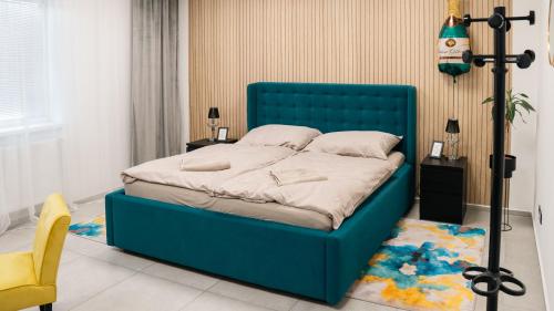 a blue bed in a room with a yellow chair at Star house Sereď in Seredʼ