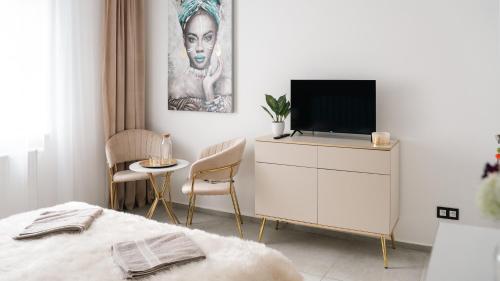 a white bedroom with a tv on a dresser at Star house Sereď in Seredʼ