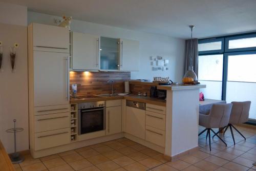 a kitchen with a sink and a refrigerator at Inselblume 50 - Ferienwohnung von privat in der Strandburg in Burgtiefe auf Fehmarn 