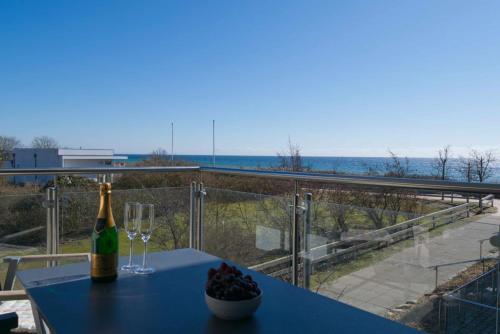 a bottle of champagne and glasses on a table with a view at Inselblume 50 - Ferienwohnung von privat in der Strandburg in Burgtiefe auf Fehmarn 