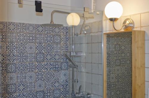 La salle de bains est pourvue de carrelage bleu et blanc. dans l'établissement Inselblume 37 - Ferienwohnung mit Meerblick im Stranddistelweg 58, à Burgtiefe auf Fehmarn 
