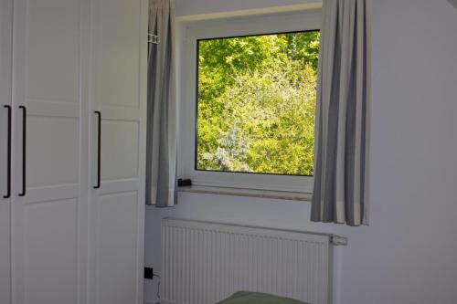 une fenêtre dans une pièce avec des murs blancs et des rideaux dans l'établissement Inselblume 34 - Ferienwohnung mit Loggia, à Burg