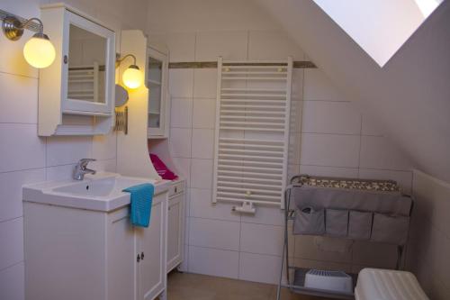 a white bathroom with a sink and a toilet at Inselblume 09 - Ferienwohnung an der Reiterkoppel auf Fehmarn in Neue Tiefe Fehmarn