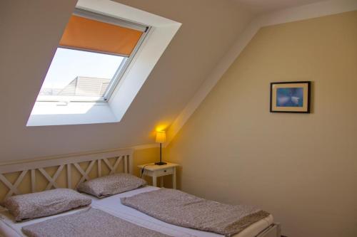 a bedroom with a bed with a window at Inselblume 09 - Ferienwohnung an der Reiterkoppel auf Fehmarn in Neue Tiefe Fehmarn