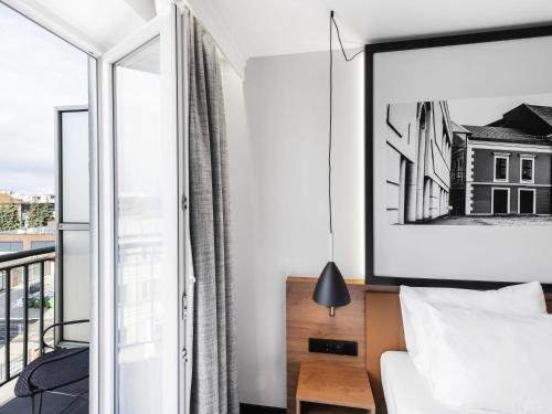 a bedroom with a bed and a balcony at MERCURE KLAIPEDA CITY HOTEL, Meetings, Events, Restaurant & Bar - Accor Group, Pet Stay FREE in Klaipėda