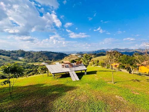 a picnic table on top of a field with a view at Chalés Terras Altas in Gonçalves