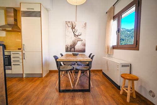 a kitchen and dining room with a table and chairs at Retiro de Montaña con Acceso Directo a Grandvalira I Cabirol in Sant Pere