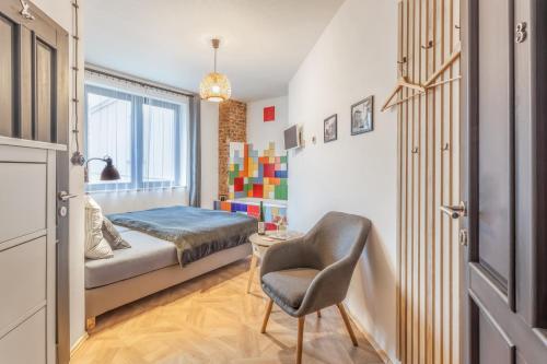a small bedroom with a bed and a chair at Penzion Malý in Krnov