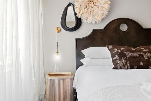 a bedroom with a bed with a wooden headboard and a mirror at The Lexington - Serene Apartment, 5 min to DC with Free Parking and Metro in Arlington