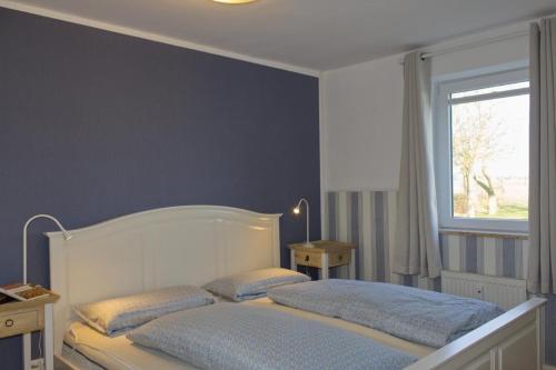 a bedroom with a bed with two pillows on it at Inselblume 35 - Moderne Ferienwohnung in Neue Tiefe in Neue Tiefe Fehmarn