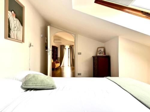 a bedroom with a white bed and a mirror at La Mansarda di Stella in Rieti