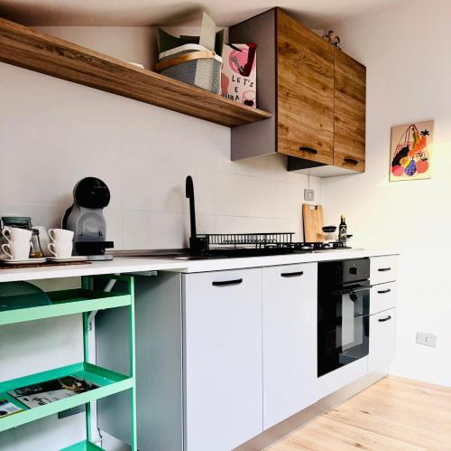 a kitchen with white cabinets and black appliances at La Mansarda di Stella in Rieti