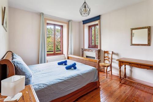 a bedroom with a bed with blue pillows on it at Le Gaumier in Cugand